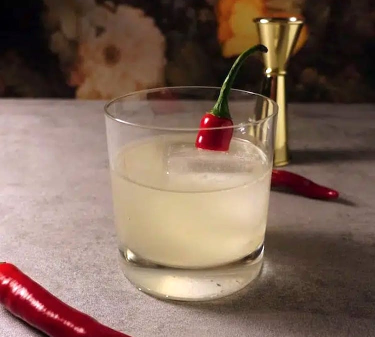 Picante de la Casa cocktail mit chilis neben jigger
