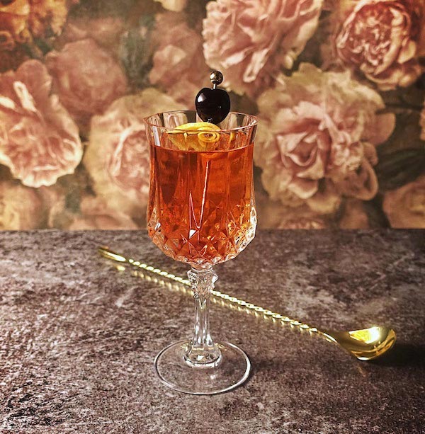 Tuxedo Cocktail vor Blütenhintergrund